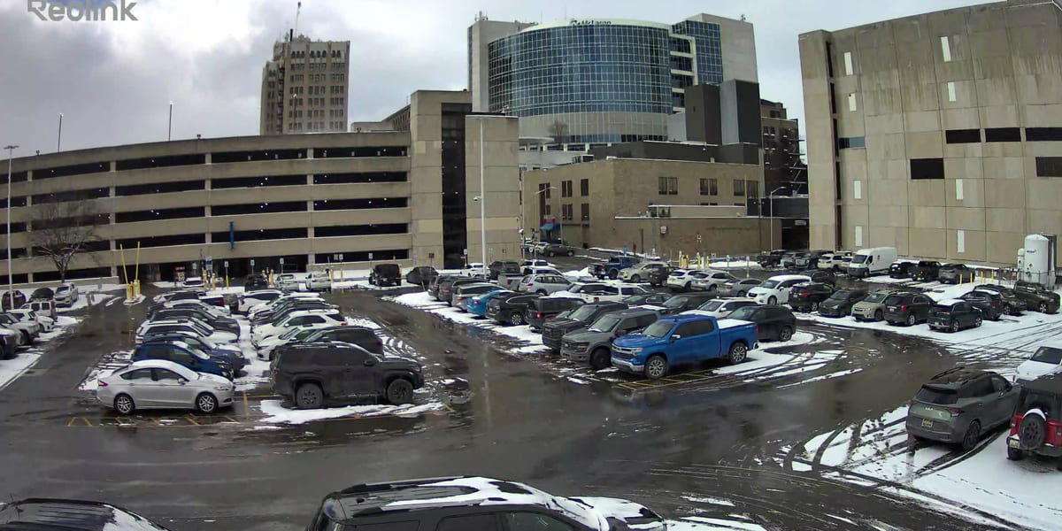 Treated commercial parking lot with vehicles and buildings after winter maintenance